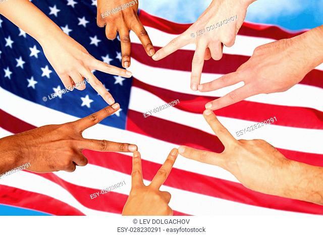 diversity, patriotism, ethnicity, international and people concept - group of hands showing peace hand sign over american flag background