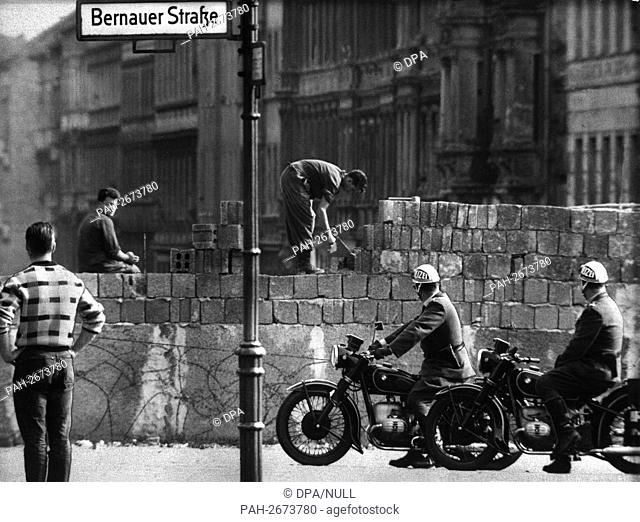 Workers add layers of brick to the Berlin Wall on Bernauer Strasse where critical incidents had occurred almost every evening