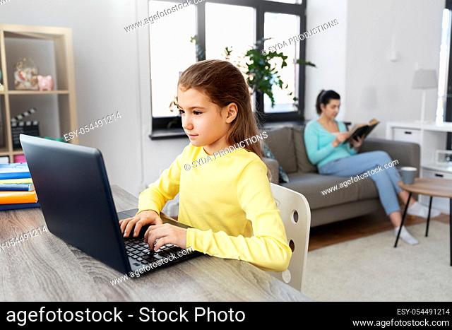 student girl with laptop learning online at home