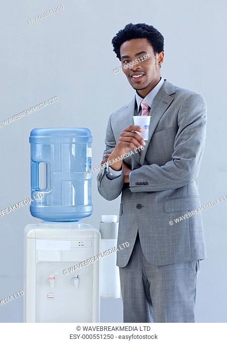 Afro-American businessman with a water cooler in office