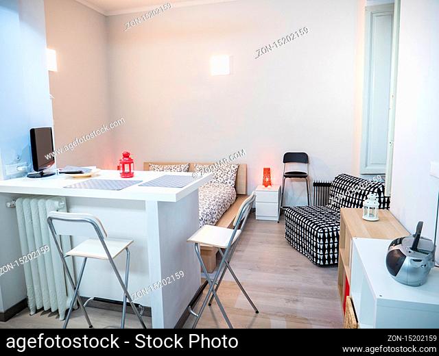 Small cozy bedroom interior furnished with comfortable soft bed and chair in contemporary apartment