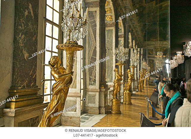 Golden statues holding lamps in the Hall of Mirrors. Chateau of Versailles. France