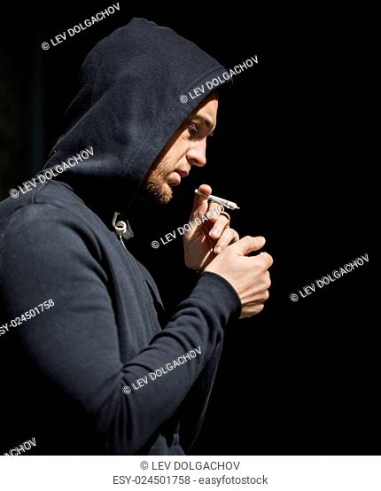 drug use, substance abuse, addiction, people and smoking concept - close up of addict lighting up marijuana joint with lighter