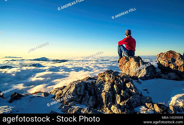 Mountaineer enjoying sunset on the top of Aggenstein in winter. Allgäu Alps, Bavaria, Germany, Europe