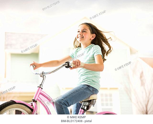 Caucasian girl riding bicycle in neighborhood