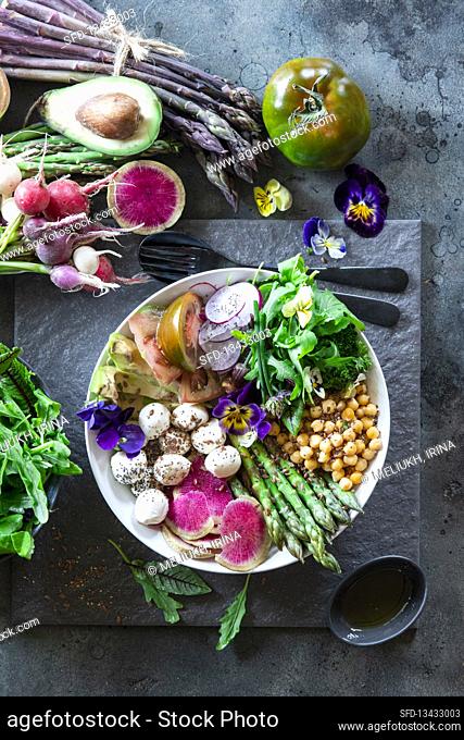 Buddha bowl with asparagus, watermelon radish, tomatoes and chickpeas