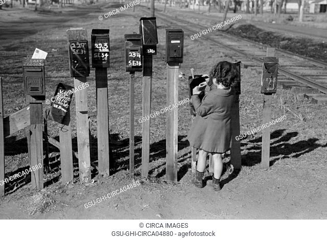 Little Girl Getting Mail from Mailbox, Suburb of Oklahoma City, Oklahoma, USA, Russell Lee, Farm Security Administration, February 1940