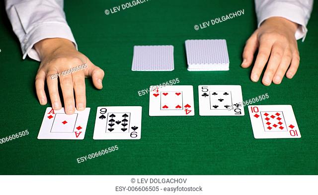 casino, gambling, poker, people and entertainment concept - close up of holdem dealer hands with playing cards