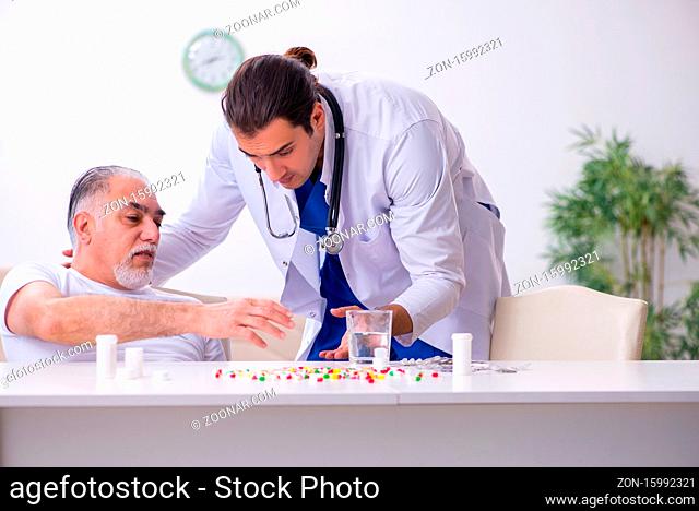 Young doctor visiting old male patient at home