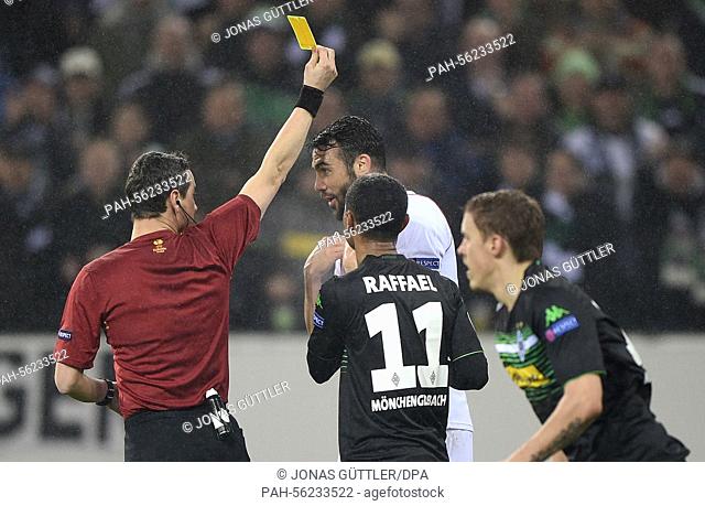 Referee Marijo Strahonja (l) shows Sevilla's Vicente Iborra (c, back) the yellow card as Moenchengladbach's Raffael (r) argues with him during the Europa League...