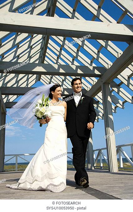 Caucasian mid-adult bride and groom walking together