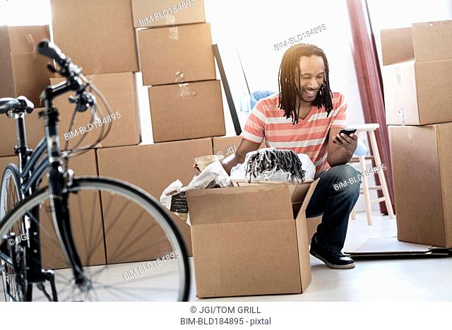 Black man unpacking boxes in new home