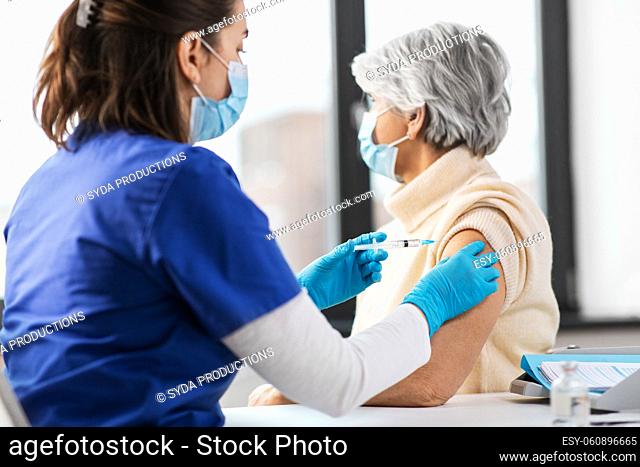 nurse with syringe making injection to woman