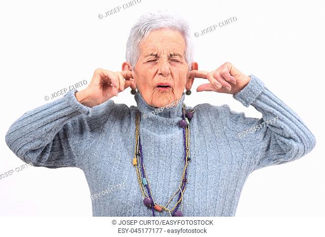senior woman making noise hurting her ears on white background