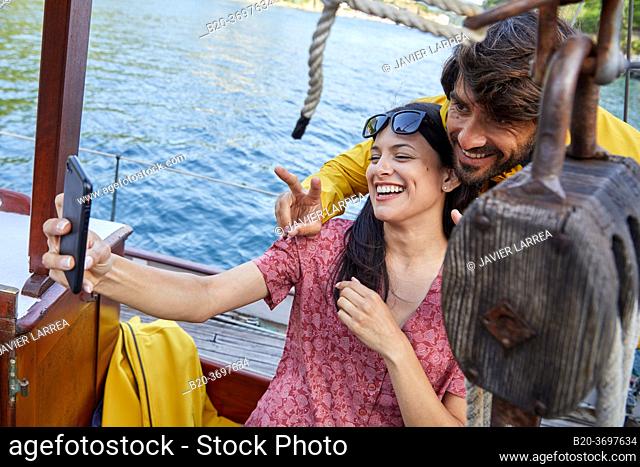 Couple taking a selfie, Sailboat, Port of Pasaia, Gipuzkoa, Basque Country, Spain, Europe