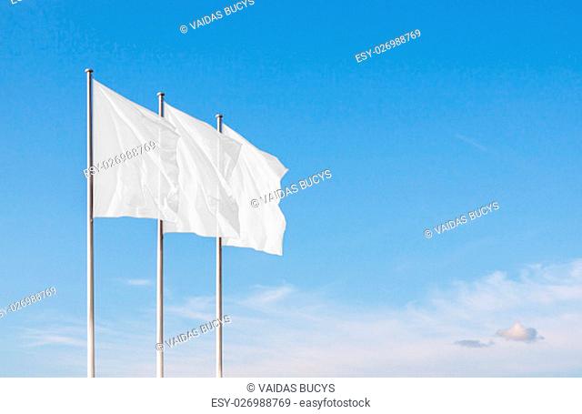 Three white blank flags waving in the wind against cloudy sky. Perfect mockup to add any logo, symbol or sign