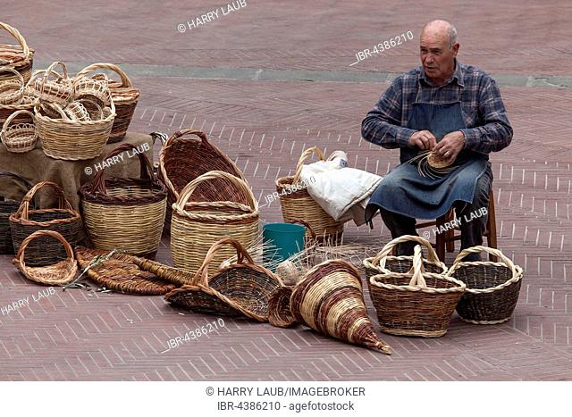 Basket weaver, man on Piazza delle Erbe making baskets, San Gimignano, Province of Siena, Tuscany, Italy