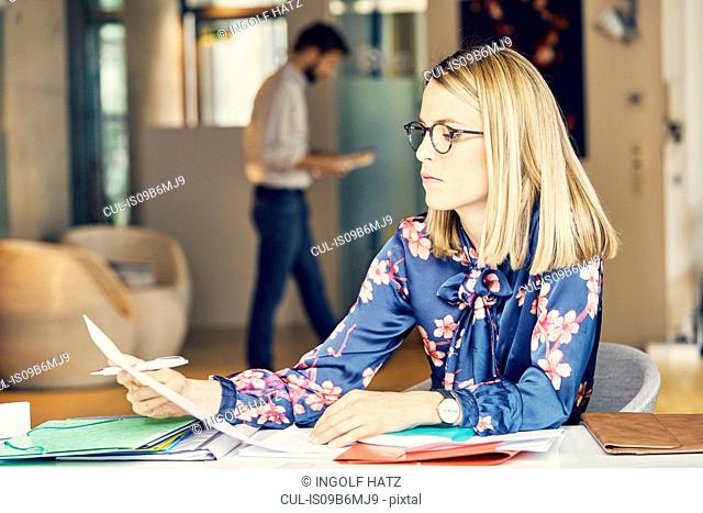 Businesswoman doing paperwork at desk