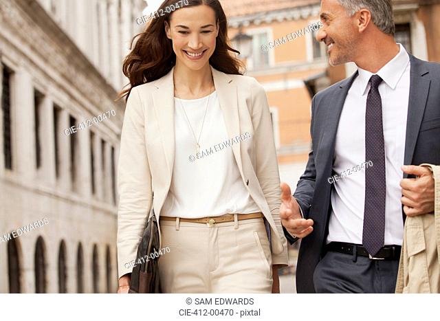 Smiling businessman and businesswoman walking