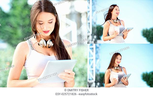 Beautiful young woman with vintage music headphones around her neck and a take away coffee cup, surfing internet on a tablet pc and standing against background...