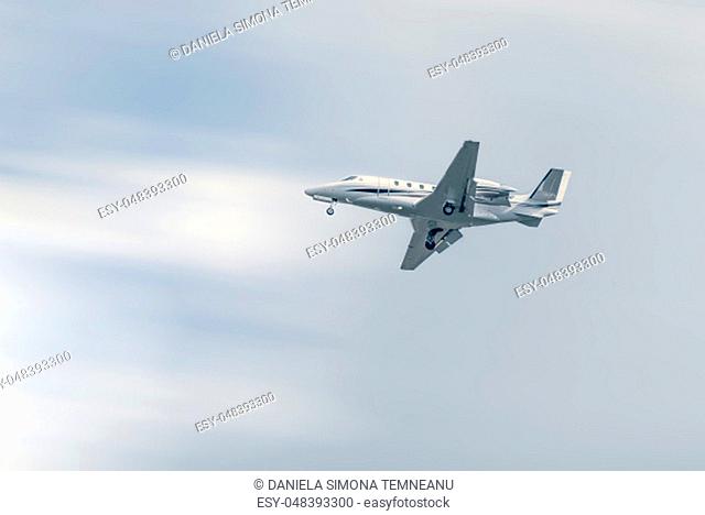 Small commercial airplane flying at low altitude under a blue sky
