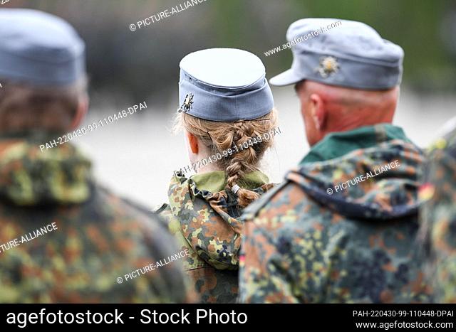 30 April 2022, Bavaria, Munich: A reservist has her hair braided into a pigtail, taken during a roll call at the Fürst Wrede Barracks