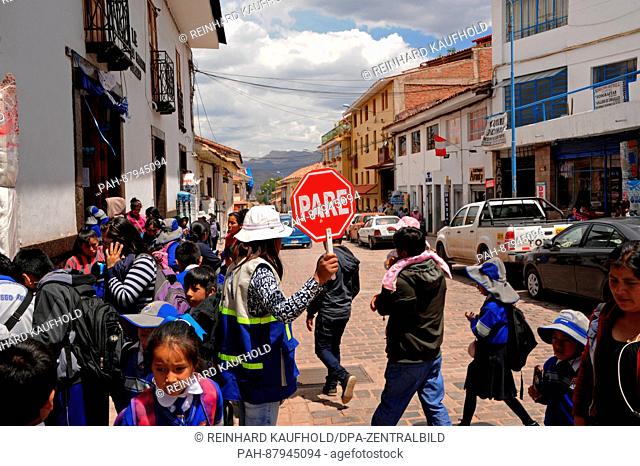 Out and about in the old capital of the powerful Inca empire and the later colonial town of Cuzco. Schoolchildren are led safely over a street in the Old Town
