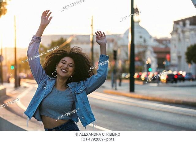 Portrait carefree, exuberant young woman on urban street, Lisbon, Portugal