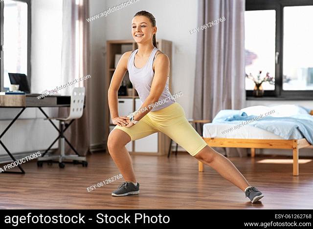 happy teenage girl exercising at home