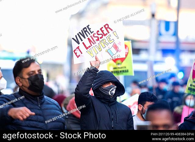 20 November 2020, Schleswig-Holstein, Nützen: A demonstrator holds a sign with the inscription ""Vivre et laisser vivre"" (live and let live) and a French flag...