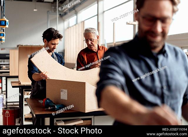 Senior businessman with colleague making furniture in industry