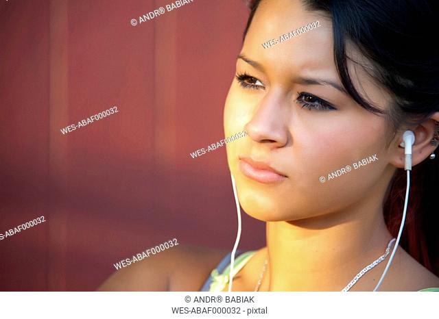 USA, Texas, Teenage girl with head phones, close up