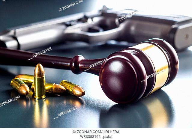 Judge gavel and gun bullets on black table