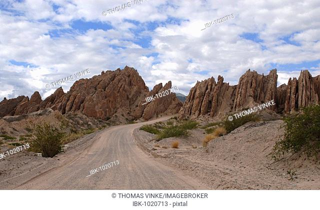 Bendy gravel road leading through the bizarre sandstone formations Quebrada de las Flechas, Province of Salta, Andes, Argentina, South America