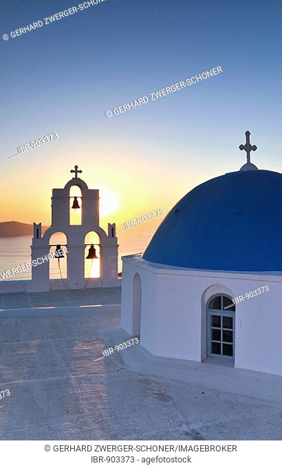 White Greek church with a blue dome and a bell tower at sunset, Firostefani, Santorini, Cyclades, Greece, Europe