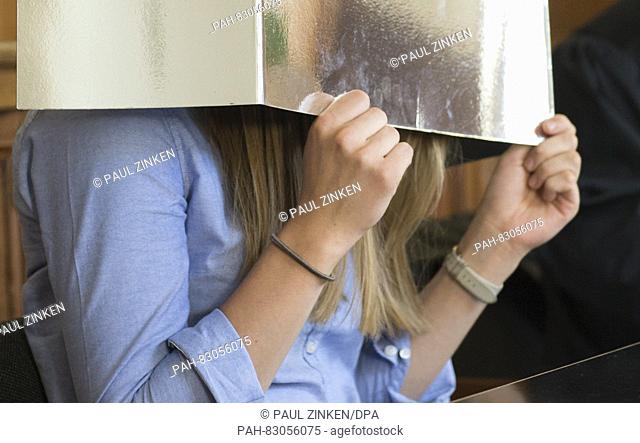 Esther S., who is accused of homicide, holds a piece of paper in front of her face in a courtroom of the Landcourt in Berlin, Germany, 24 August 2016