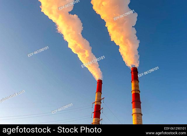 white smoke is coming out of the pipes in the blue sky. High quality photo