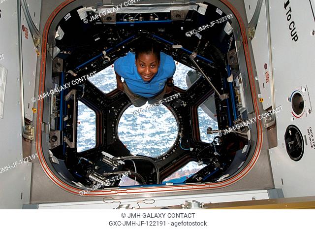 NASA astronaut Stephanie Wilson, STS-131 mission specialist, poses for a photo in the Cupola of the International Space Station while space shuttle Discovery...
