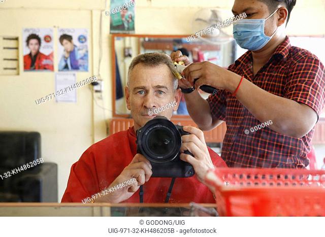 Photographer getting a haircut in Cambodia