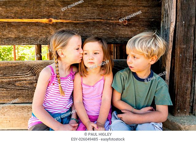 Young girl kissing her friend