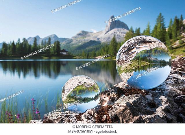 Playing with crystal balls at Lake Federa in summer time, on the background the Becco di Mezzodi, Dolomites, Cortina d'Ampezzo, Belluno, Veneto, Italy
