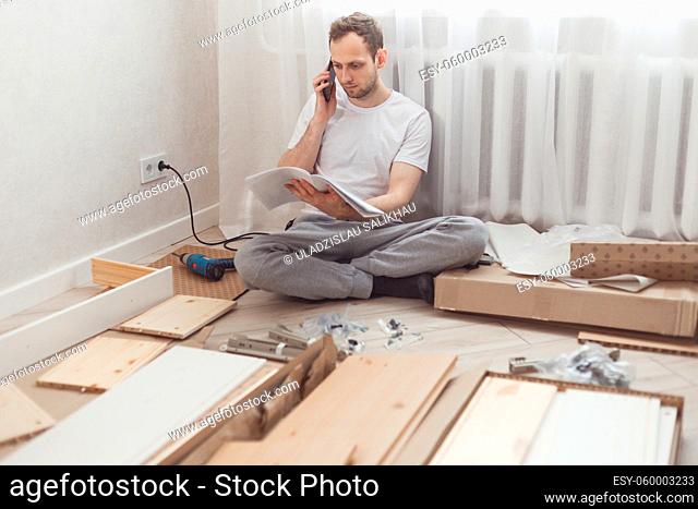 Man customer calls to help center at home during assembling new furniture, calling for a master