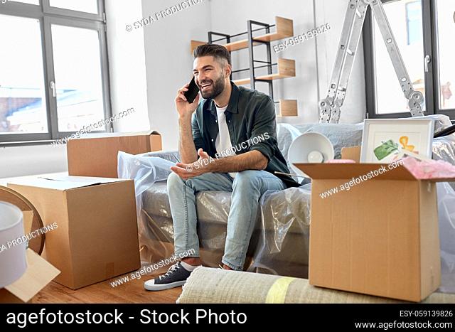 happy man calling on smartphone moving to new home