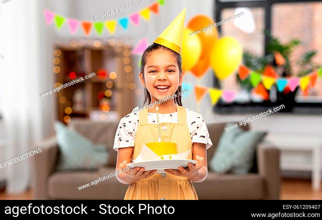 smiling girl with cake at birthday party at home