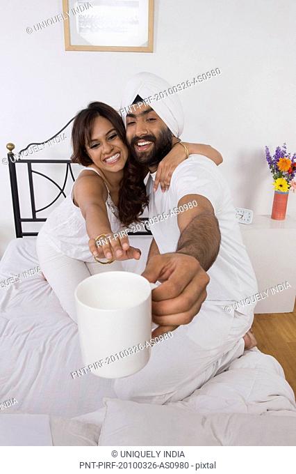 Woman reaching for a coffee cup held by her husband