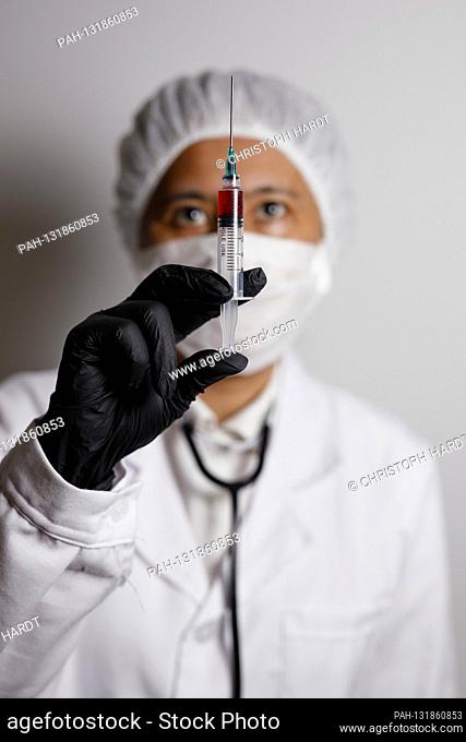 A virologist poses with a syringe for vaccination versus the corona virus (symbol photo with model) | usage worldwide. - Nuremberg/Bayern/Deutschland