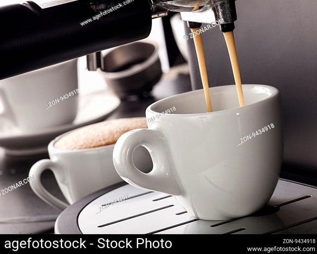 Close-up of espresso pouring from coffee machine in a white cup