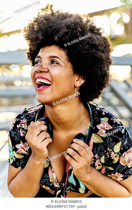 Portrait of laughing Afro-American woman with headphones