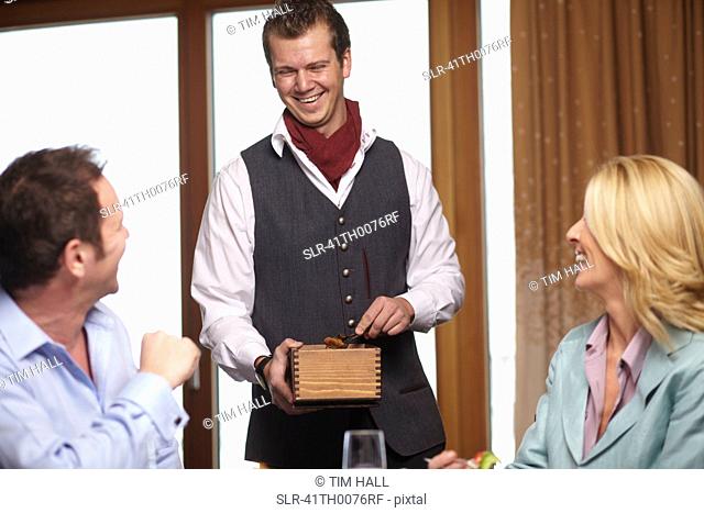 Waiter serving business people in cafe