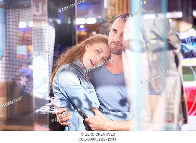 Couple shopping, looking in shop window